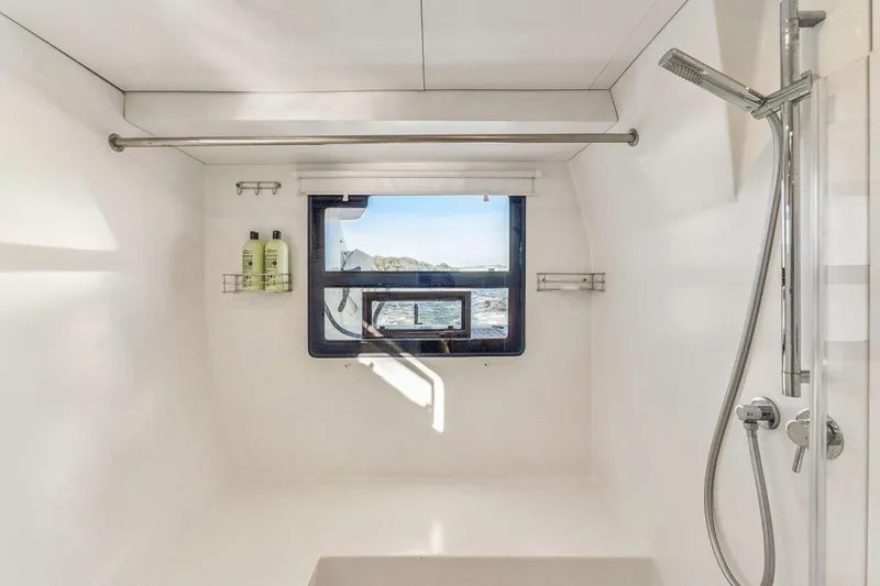 Slide: The Image of Modern yacht bathroom with ocean view, featuring a sleek shower and minimalist design. Balance 482, 2024. - 85