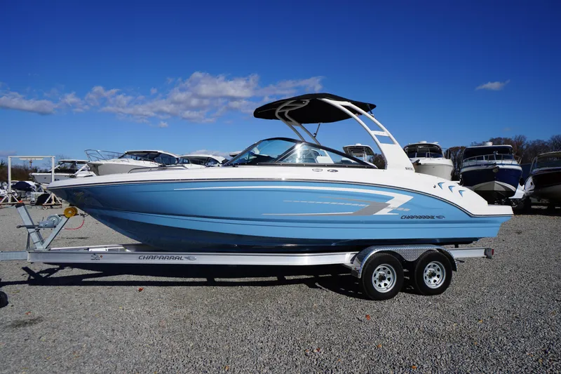 The Image of 2026 Chaparral 23 SSi boat on trailer, blue and white design, parked outdoors. - 0