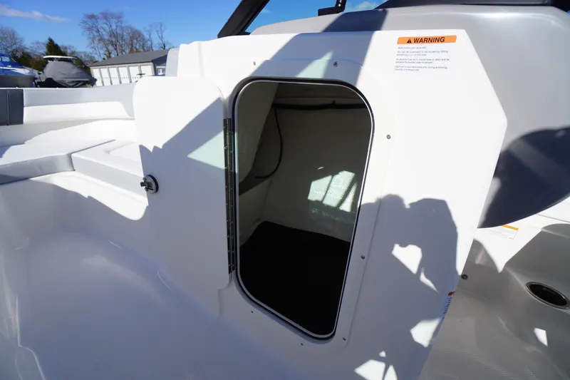 Slide: The Image of 2026 Chaparral 23 SSi boat interior storage compartment with open hatch. - 22