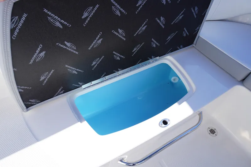 Slide: The Image of 2026 Chaparral 23 SSi boat interior with open storage compartment and branded cover. - 41