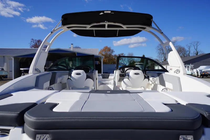 Slide: The Image of 2026 Chaparral 23 SSi boat with sleek interior and modern design under clear blue sky. - 53