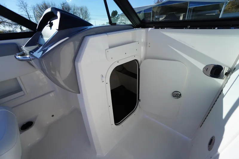 Slide: The Image of 2026 Chaparral 23 SSi boat interior with storage compartment and steering wheel. - 27