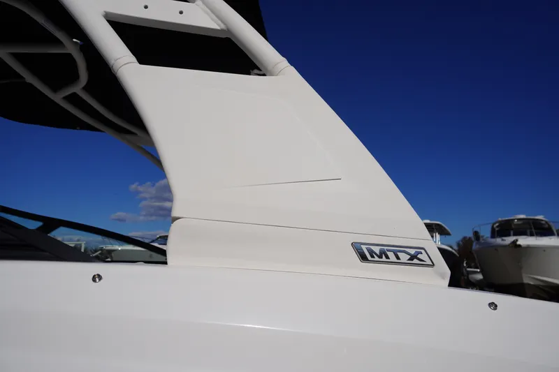 Slide: The Image of 2026 Chaparral 23 SSi boat with MTX logo, under clear blue sky. - 67