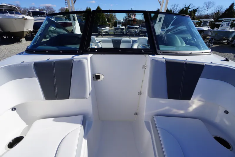 Slide: The Image of 2026 Chaparral 23 SSi boat interior with seating and windshield, displayed outdoors. - 15