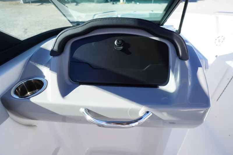 Slide: The Image of 2026 Chaparral 23 SSi boat dashboard with cup holder and storage compartment. - 24