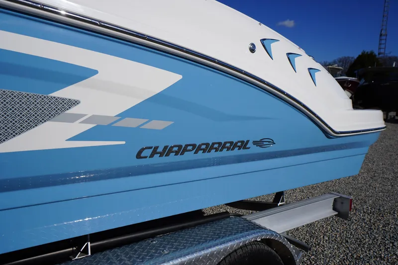 Slide: The Image of 2026 Chaparral 23 SSi boat, blue and white design, side view on trailer. - 3