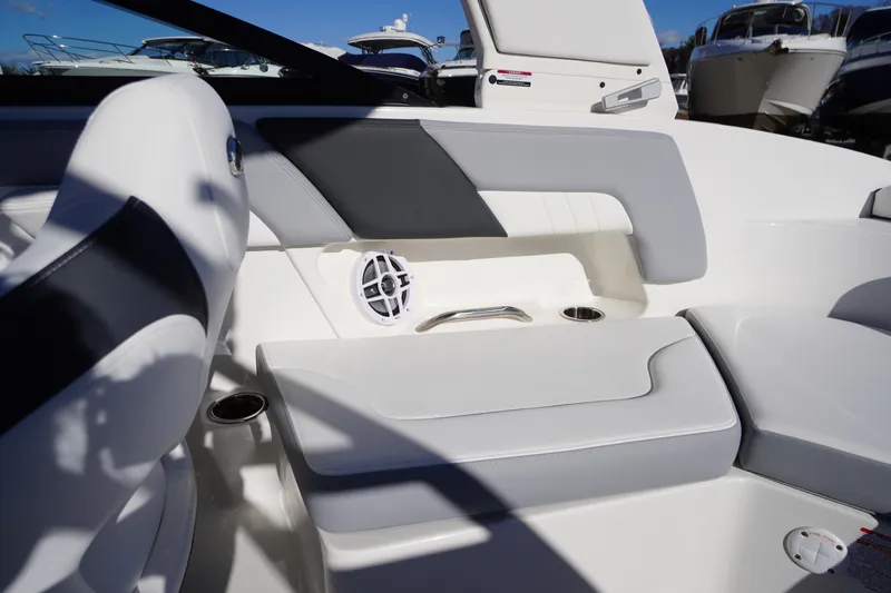 Slide: The Image of 2026 Chaparral 23 SSi boat interior with white and gray seating, cup holders, and speaker. - 36