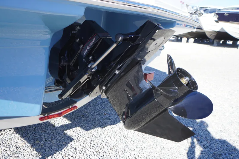 Slide: The Image of 2026 Chaparral 23 SSi boat with MerCruiser outdrive, displayed on gravel surface. - 61