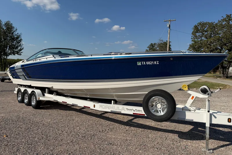 Slide: The Image of 2019 Formula 353 FASTech boat on trailer, parked outdoors under clear sky. - 2