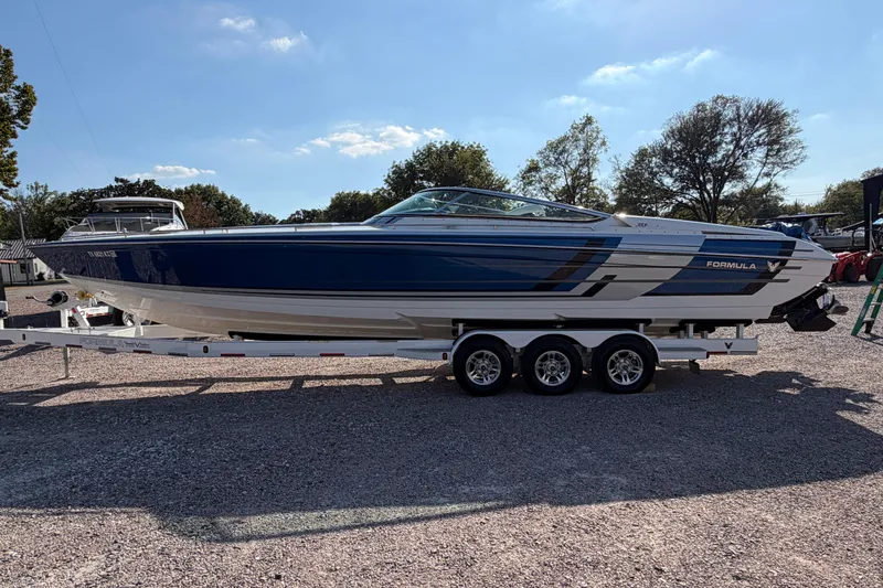 Slide: The Image of 2019 Formula 353 FASTech boat on a triple-axle trailer, parked outdoors. - 4