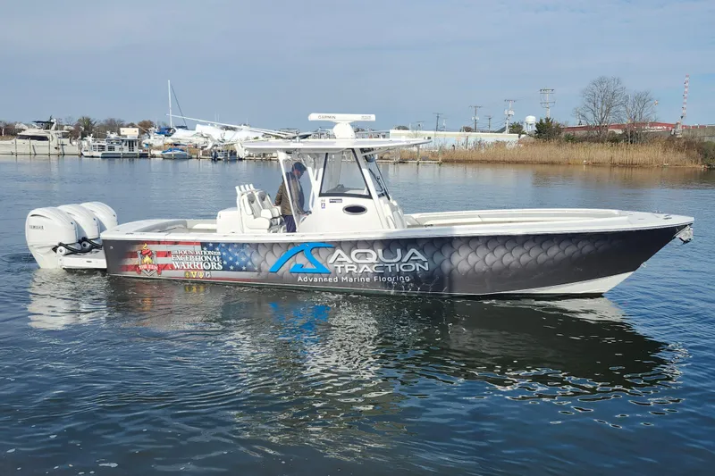 The Image of 2022 Regulator 34 boat with Aqua Traction branding on calm water. - 0