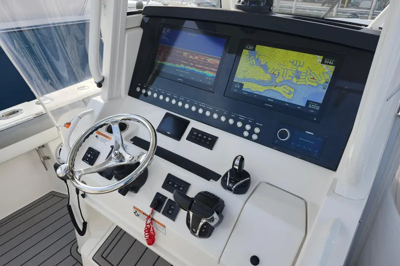 Slide: The Image of 2022 Regulator 34 boat dashboard with dual navigation screens and steering wheel. - 13