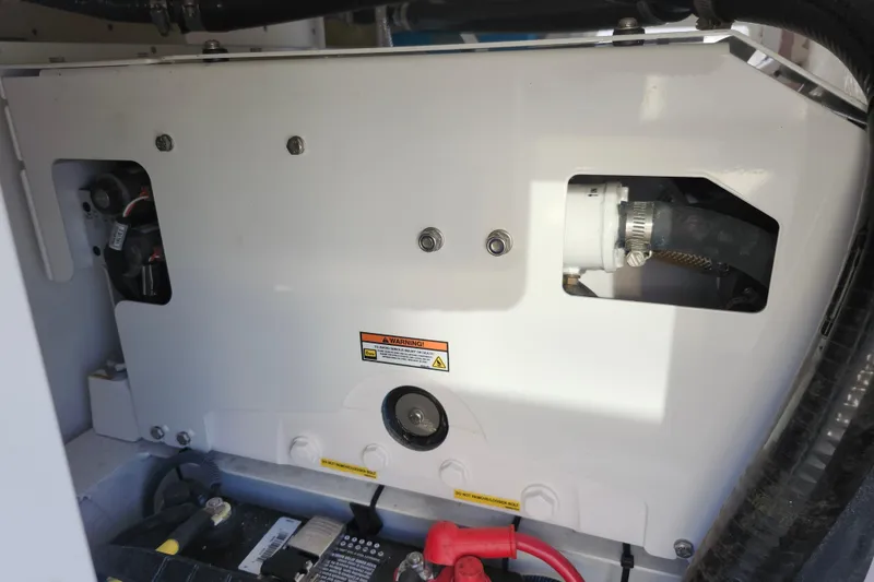 Slide: The Image of 2022 Regulator 34 engine compartment with visible components and warning label. - 18