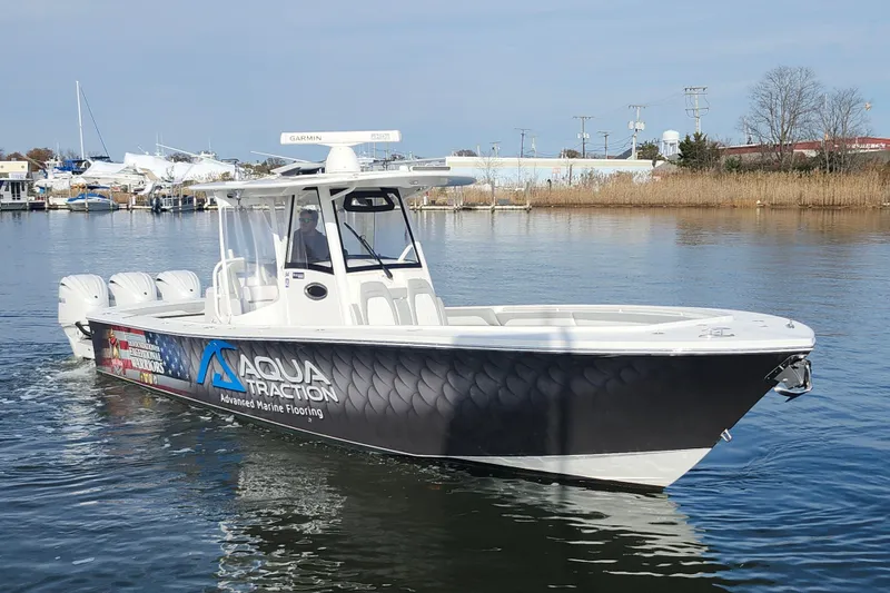 Slide: The Image of 2022 Regulator 34 boat with Aqua Traction branding on calm water. - 2