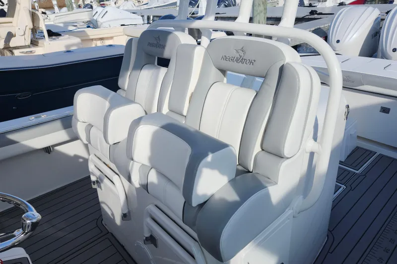Slide: The Image of 2022 Regulator 34 boat interior with white cushioned seating and helm station. - 23