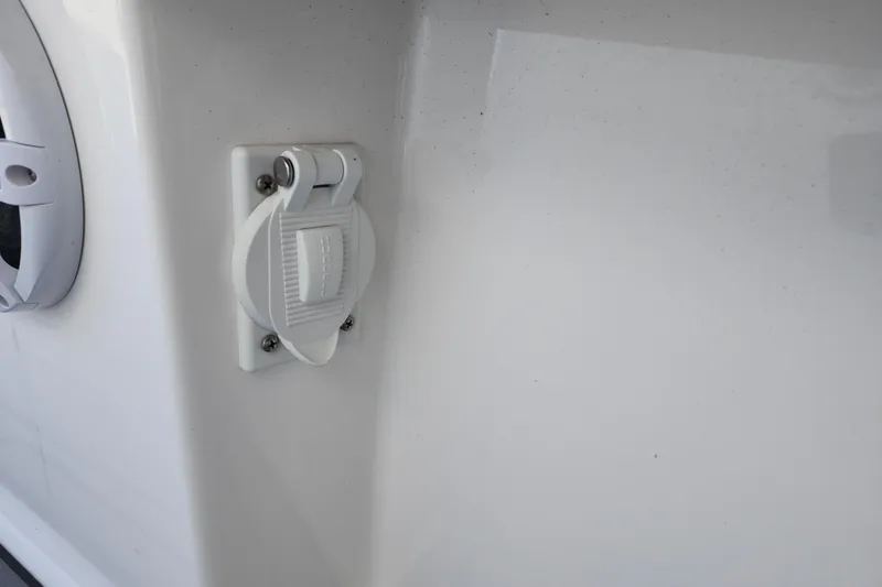 Slide: The Image of 2022 Regulator 34 boat detail showing a Hubbell electrical outlet on the white exterior. - 36