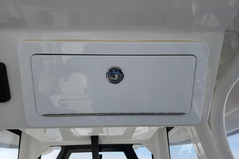 Slide: The Image of 2022 Regulator 34 boat storage compartment with sleek white finish and secure latch. - 39