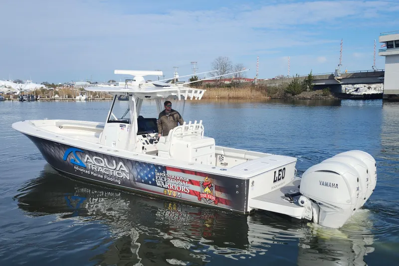 Slide: The Image of 2022 Regulator 34 boat with Aqua Traction branding, featuring dual Yamaha engines on a calm waterway. - 7