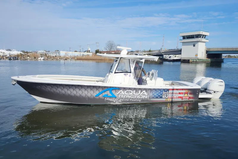 Slide: The Image of 2022 Regulator 34 boat with Aqua Traction branding on calm water. - 8