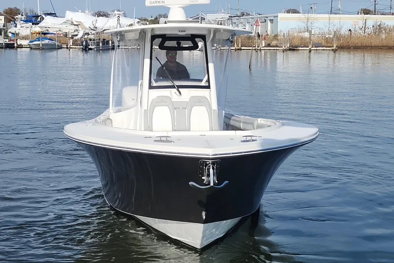 Slide: The Image of 2022 Regulator 34 boat on water, front view, with marina background. - 9