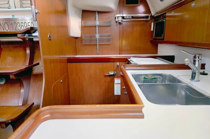 Slide: The Image of Interior of 2011 Beneteau 40 yacht kitchen with wooden cabinetry and stainless steel sink. - 10