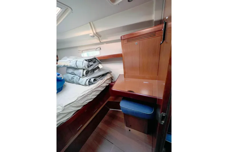 Slide: The Image of Cozy cabin interior of 2011 Beneteau 40 sailboat with wooden furnishings and bedding. - 12
