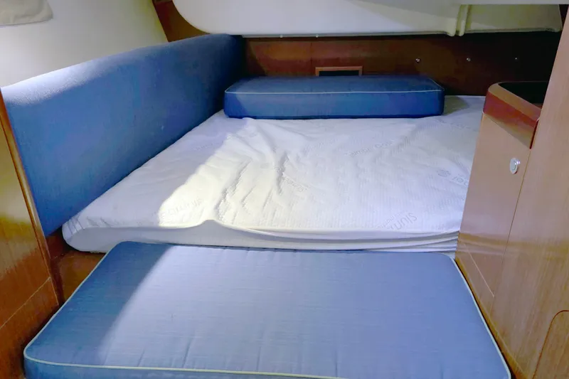Slide: The Image of Cozy cabin interior of 2011 Beneteau 40 sailboat with blue cushions and wooden finish. - 16