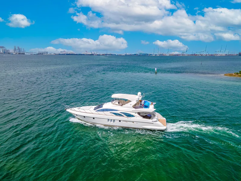 Slide: The Image of 2004 Azimut 62 yacht cruising on clear blue waters under a bright sky. - 3