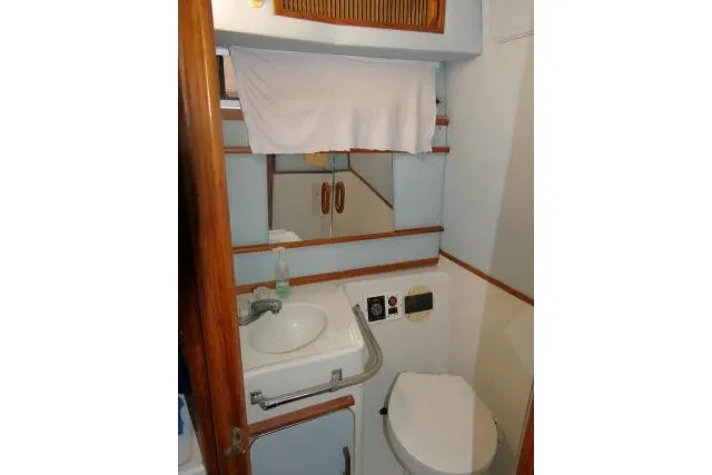Slide: The Image of 1988 Sea Ray 300 Weekender bathroom with sink, mirror, and toilet. - 13