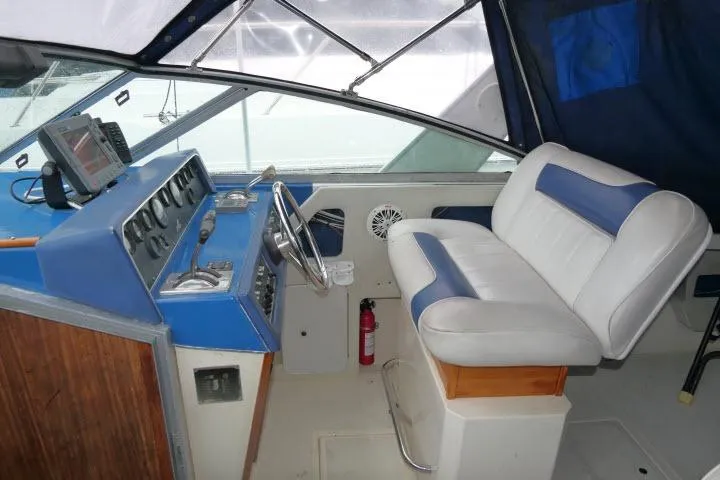 Slide: The Image of 1988 Sea Ray 300 Weekender boat interior with blue and white seating and control panel. - 15