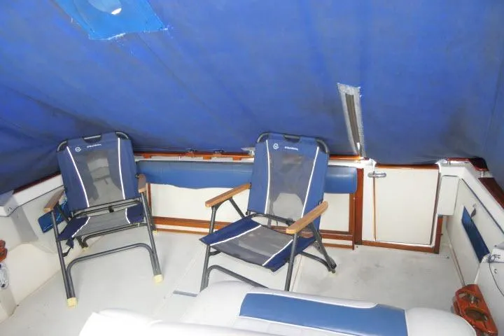 Slide: The Image of Interior of 1988 Sea Ray 300 Weekender with blue camping chairs and canopy. - 19