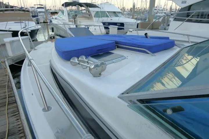 Slide: The Image of 1988 Sea Ray 300 Weekender docked, featuring blue cushions and stainless steel railings. - 20