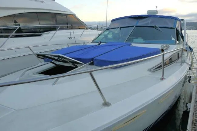 Slide: The Image of 1988 Sea Ray 300 Weekender boat docked with blue covers and sleek design. - 23