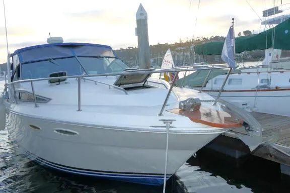Slide: The Image of 1988 Sea Ray 300 Weekender docked at marina, featuring sleek design and blue canopy. - 26
