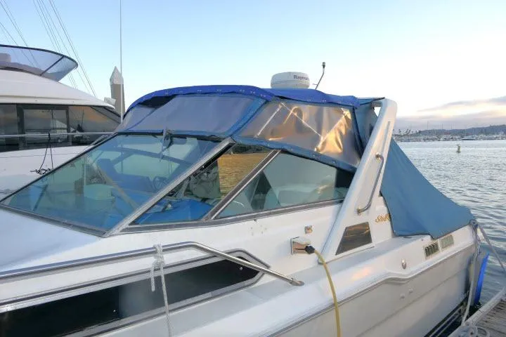 Slide: The Image of 1988 Sea Ray 300 Weekender boat with blue canopy docked at sunset. - 28