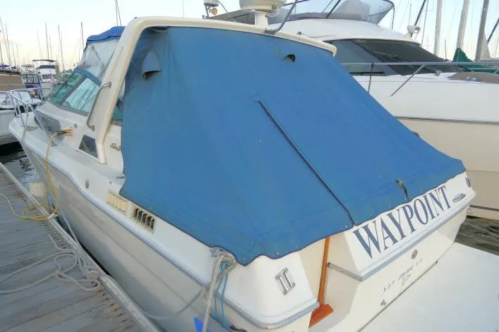Slide: The Image of 1988 Sea Ray 300 Weekender boat docked with blue cover, named "WAYPOINT". - 29