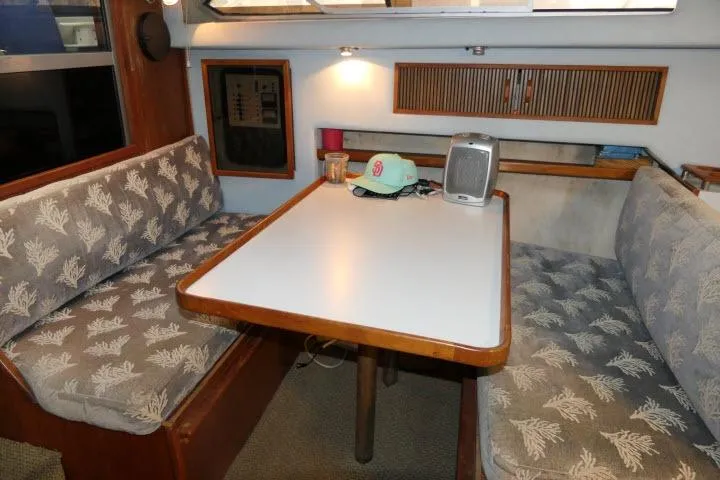 Slide: The Image of 1988 Sea Ray 300 Weekender interior with cozy dining area and patterned seating. - 4