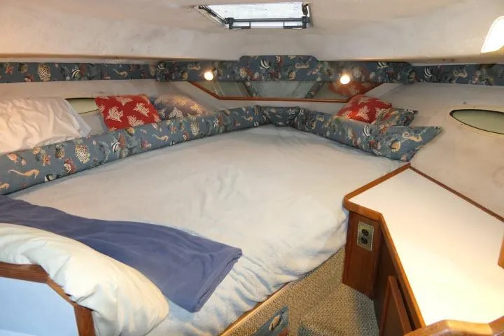 Slide: The Image of 1988 Sea Ray 300 Weekender cabin with cozy bed and nautical-themed decor. - 7