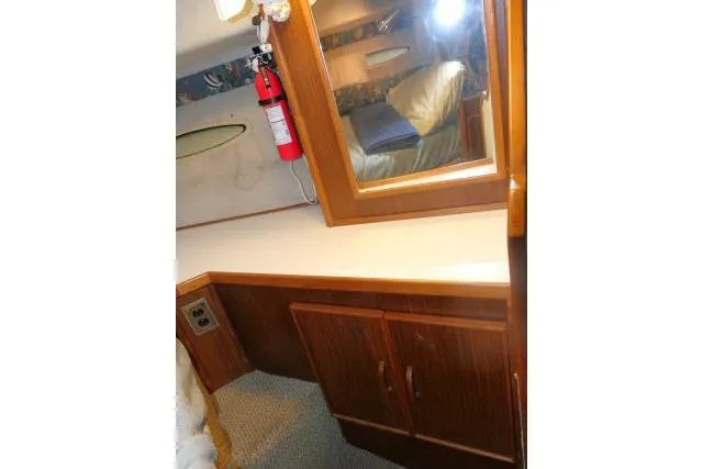 Slide: The Image of 1988 Sea Ray 300 Weekender cabin interior with wooden cabinetry and fire extinguisher. - 8