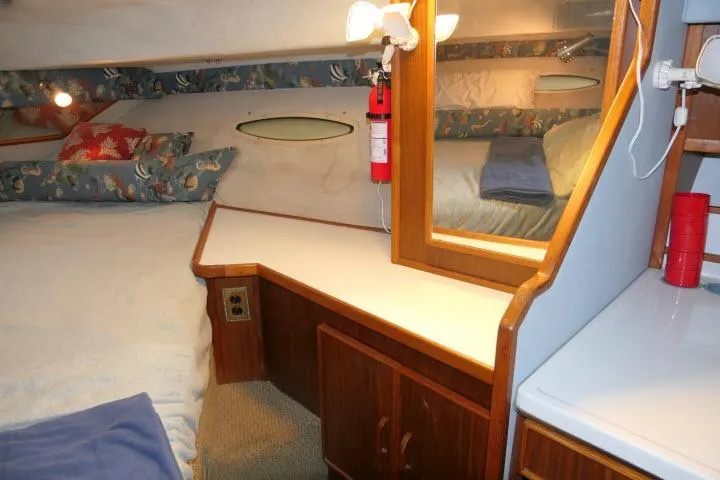 Slide: The Image of 1988 Sea Ray 300 Weekender cabin interior with bed, mirror, and wooden cabinetry. - 9