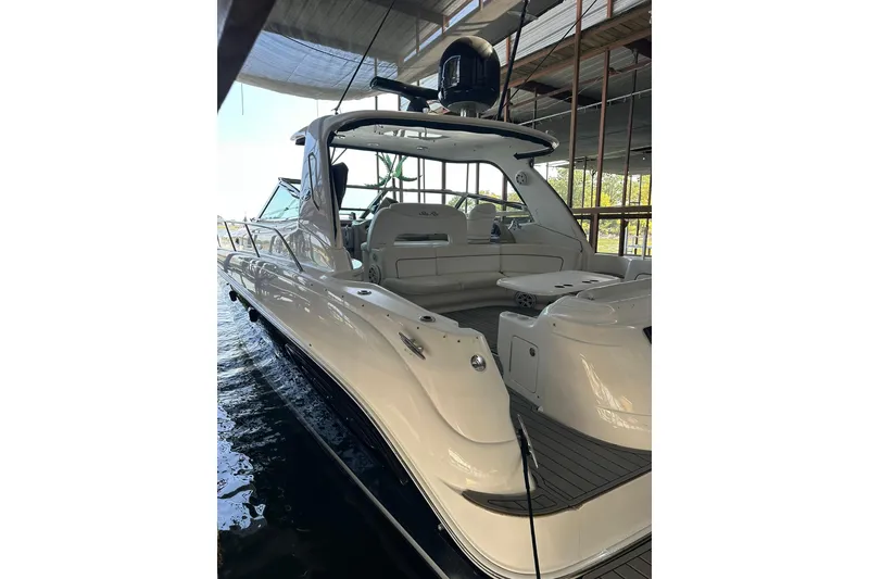 The Image of 2003 Sea Ray 460 Sundancer yacht docked in a marina, showcasing sleek design and spacious deck. - 0