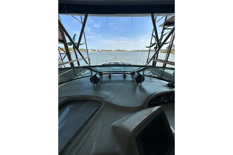 Slide: The Image of 2003 Sea Ray 460 Sundancer yacht cockpit view with scenic water backdrop. - 14