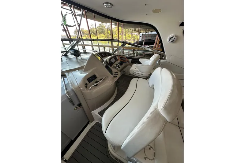 Slide: The Image of 2003 Sea Ray 460 Sundancer helm with white seating and modern controls. - 15