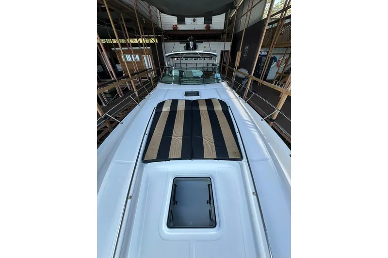 Slide: The Image of 2003 Sea Ray 460 Sundancer yacht in storage, featuring a striped sun pad. - 18