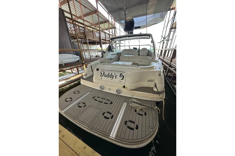 Slide: The Image of 2003 Sea Ray 460 Sundancer yacht docked, featuring spacious deck and luxurious seating. - 4