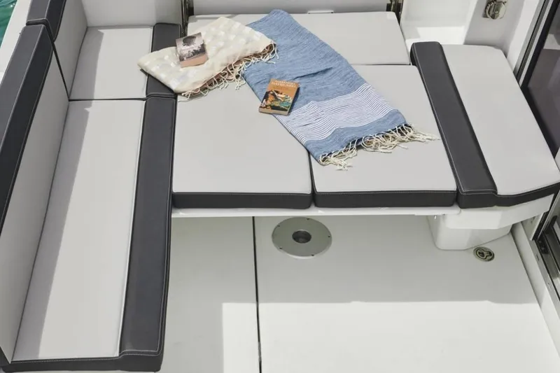 Slide: The Image of 2024 Jeanneau NC Weekender 795 Series 2 boat seating with blankets and books. - 15