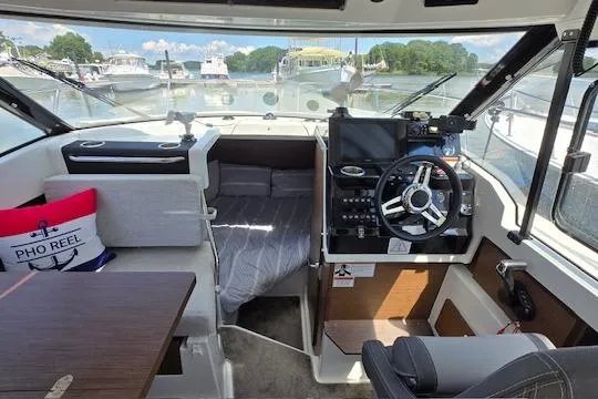 Slide: The Image of 2024 Jeanneau NC Weekender 795 Series 2 interior with helm, seating, and cabin view. - 7