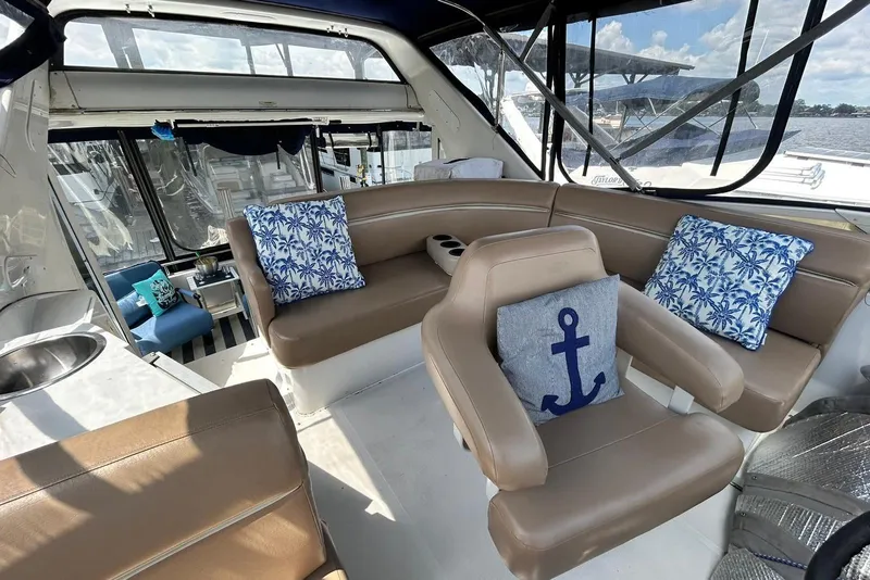 Slide: The Image of Luxurious 2002 Carver 444 Cockpit Motor Yacht interior with plush seating and nautical-themed cushions. - 11