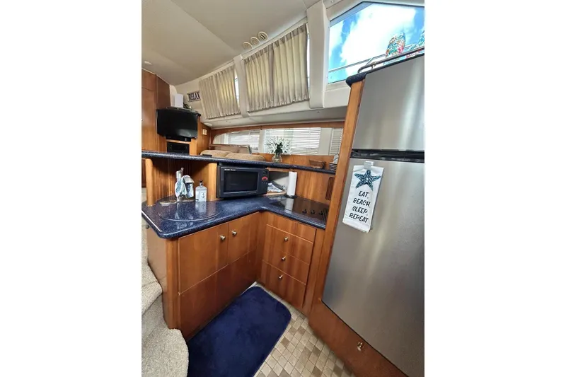 Slide: The Image of Interior of 2002 Carver 444 Cockpit Motor Yacht with kitchen amenities and decor. - 15