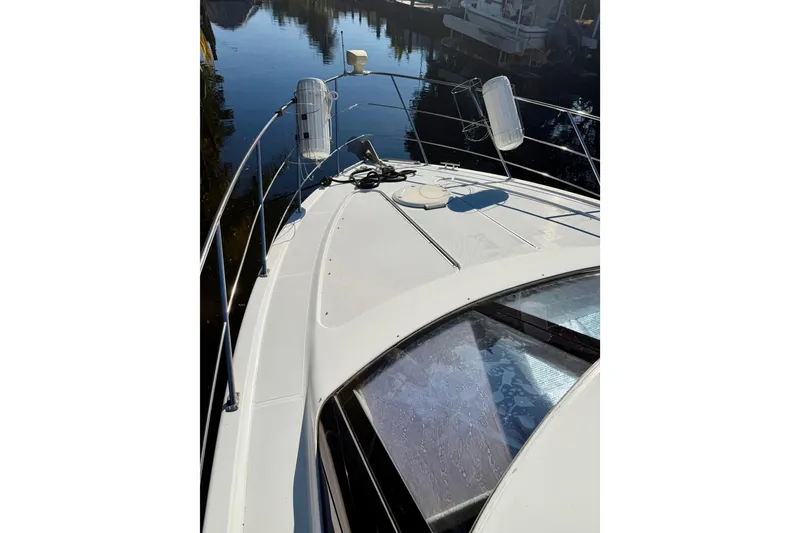 Slide: The Image of 2002 Carver 444 Cockpit Motor Yacht deck view with calm water reflection. - 23